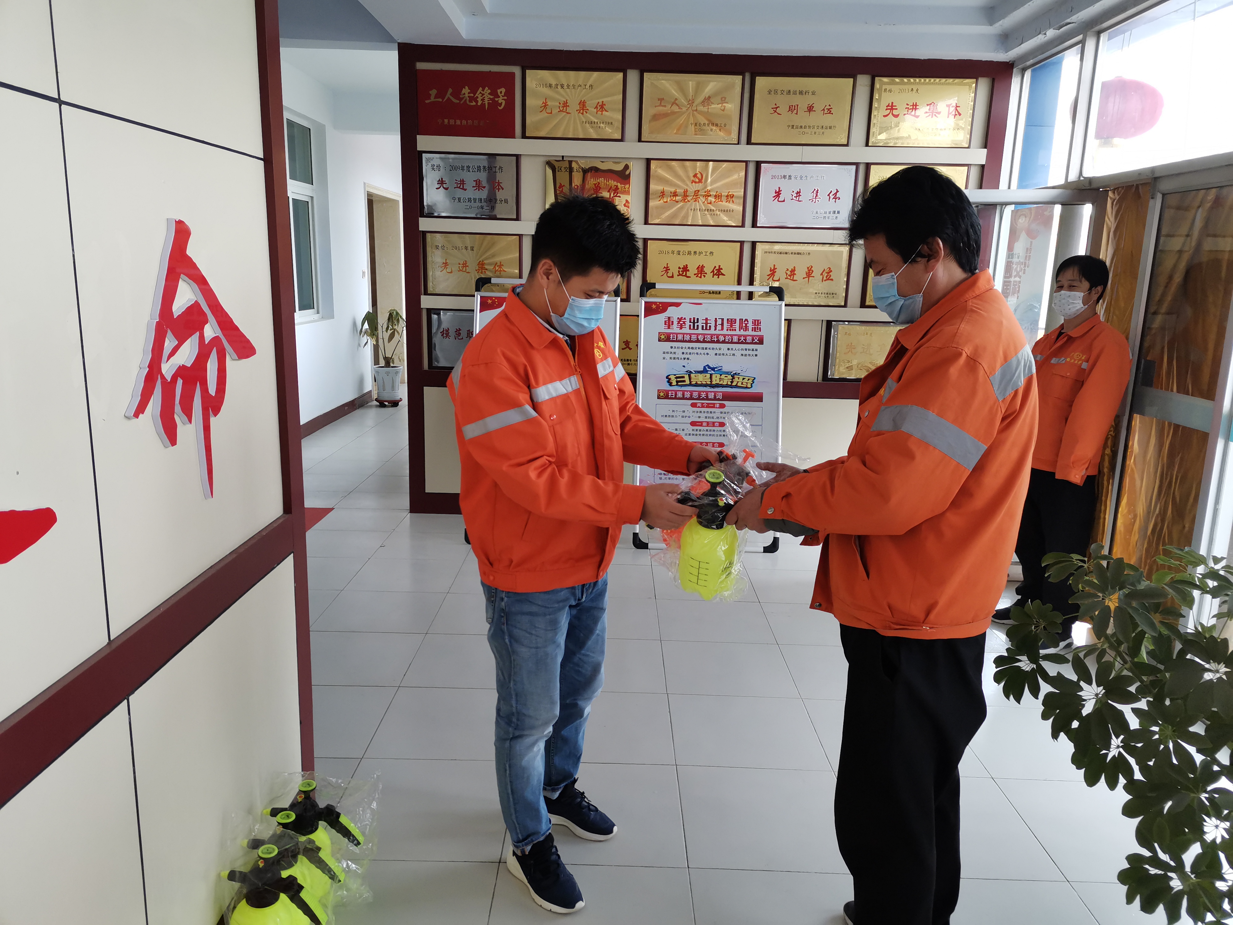 技術(shù)員趙棟（左）發(fā)放消毒水等物資.jpg