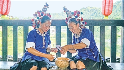     程陽橋上，侗族婦女在展示制作侗族刺繡產品。繡品圖案精美、色彩艷麗，成為當地特色產業。